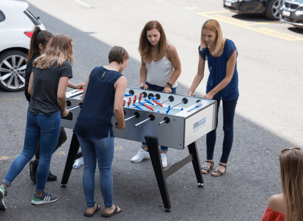 Pausen: Run my Accounts Team beim Tischfussball Spielen vor dem Büro.